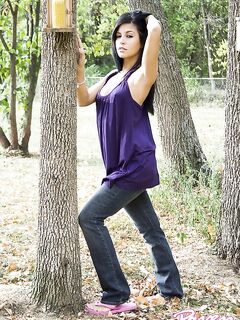 Flirtatious Honey Raven Riley With Jet Black Hair Gives Seductive Striptease Near The Tree.